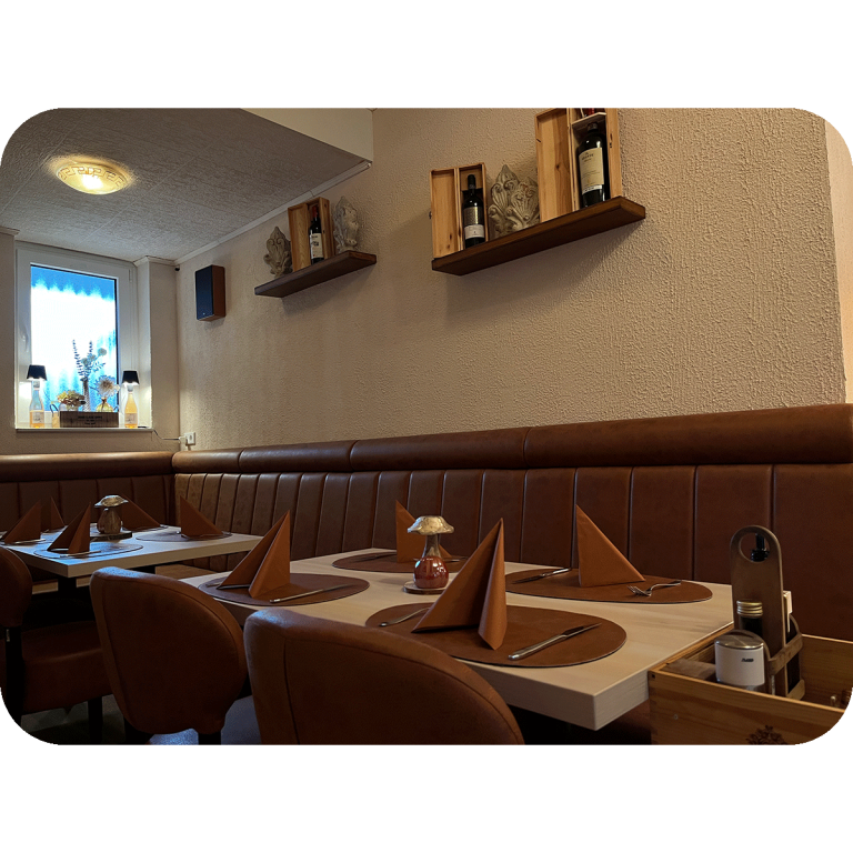 Ristorante Apollo in Blomberg. Gemütlicher Restaurantbereich mit gedeckten Tischen und braunen Lederbänken.